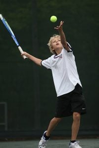 edad para comenzar en el tenis - chico realizando un servicio