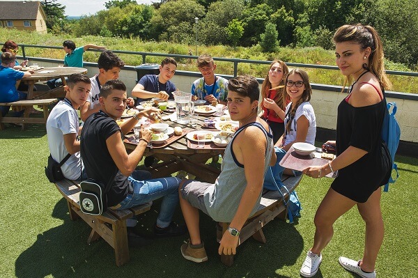 beneficios de los campamentos - comida entre compañeros en un campamento