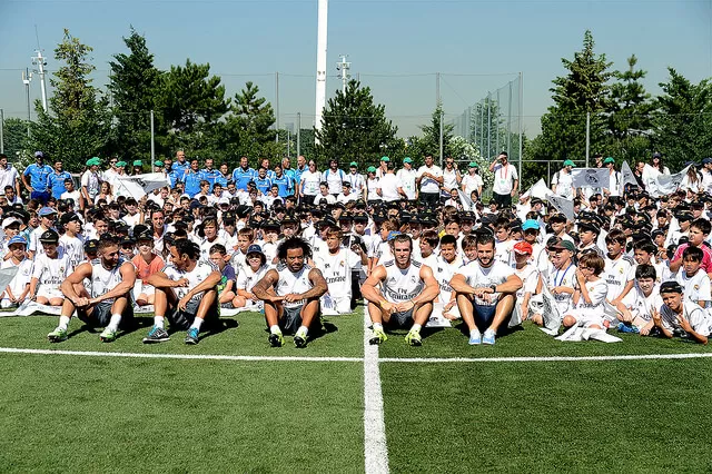 beneficios de los campamentos - niños del campamento del Real Madrid con los jugadores
