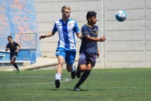 Dos futbolistas profesionales disputan un balón durante un partido