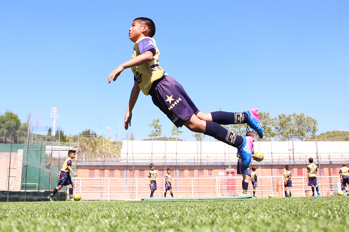 Alumno rematando de cabeza en un entrenamiento de la academia de fútbol de alto rendimiento en Barcelona