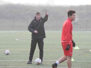 Entrenador del campamento de fútbol de alto rendimiento dando instrucciones