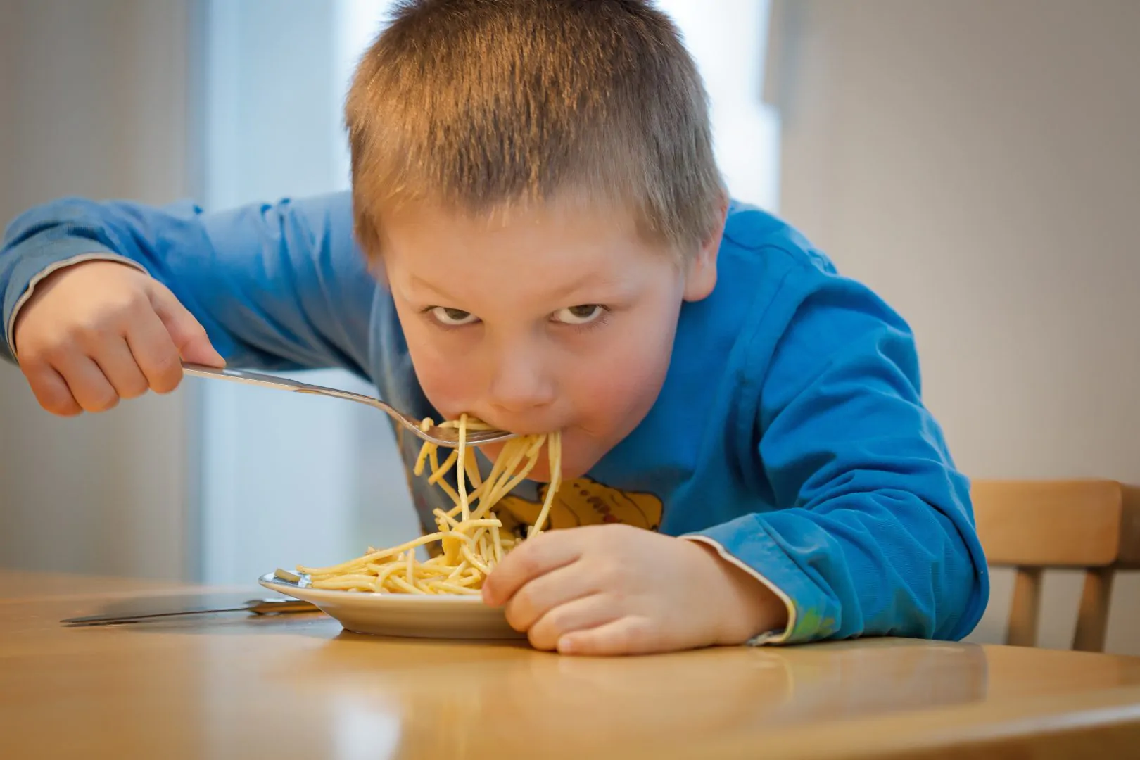 joven comiendo espaguetis recomendados por la dieta para niños deportistas