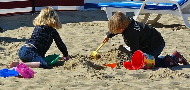 Pequeños haciendo actividades de verano para niños en la playa