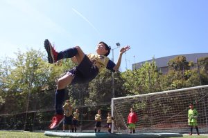 alumnos del campamento de fútbol de Semana Santa rematando