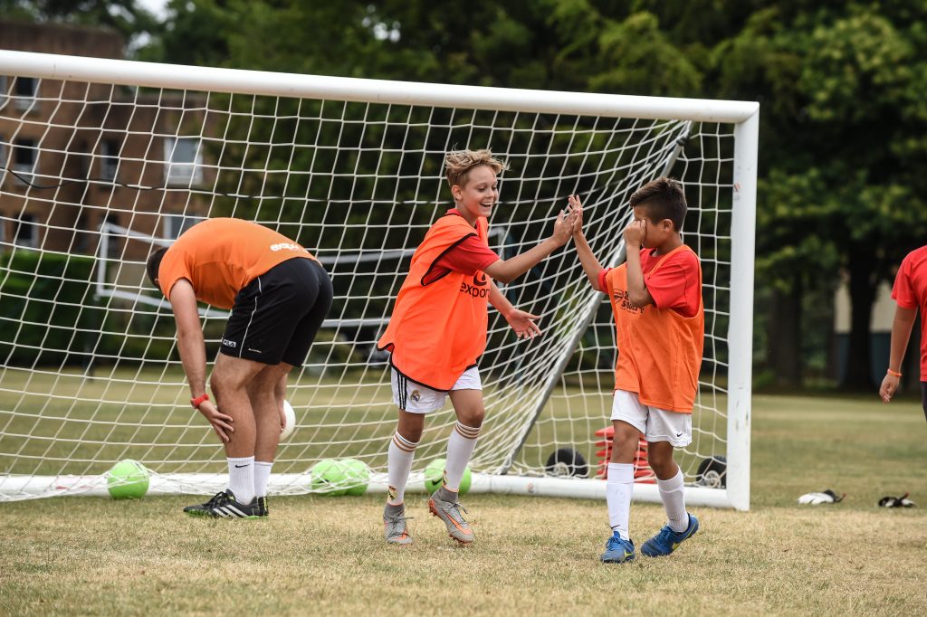 Kids high fiving when coaching youth soccer