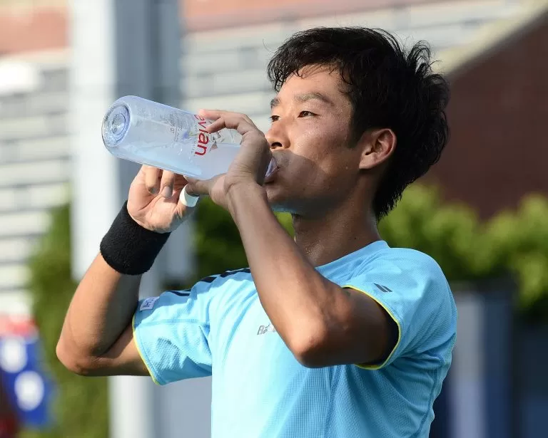 Jugador de tenis bebiendo agua - nutrición deportiva para niños